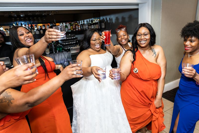 Bride toasting with her bridesmaids at the bar