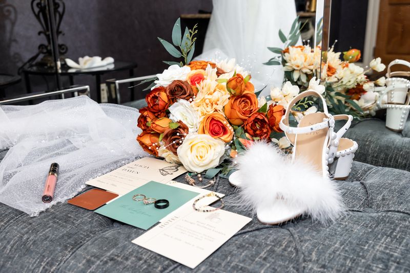 Bridal flatlay with bouquet, invitations, and shoes