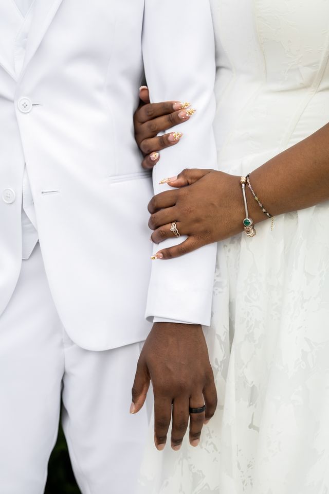 Close-up of the couple's hands and wedding rings