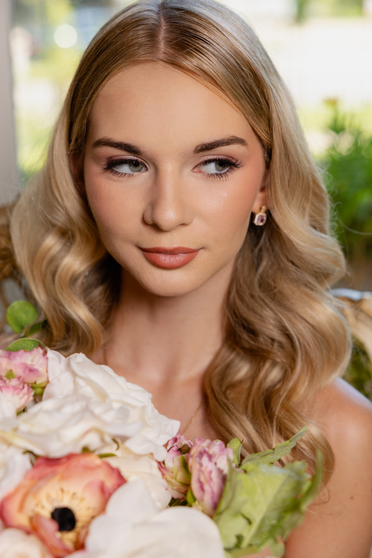 Close-up bridal portrait with soft glam makeup and bouquet
