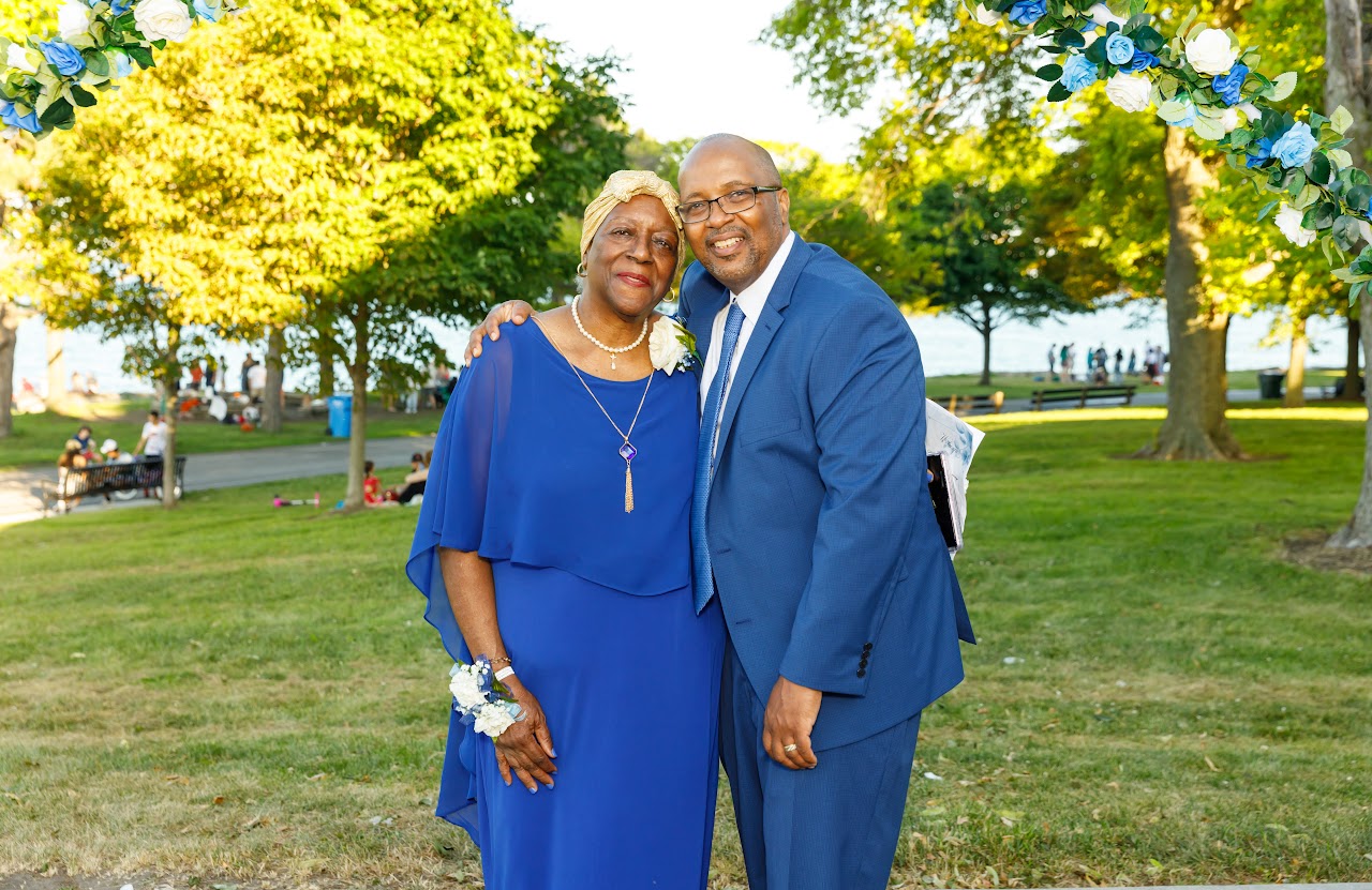 Couple beneath the floral arch by the lake