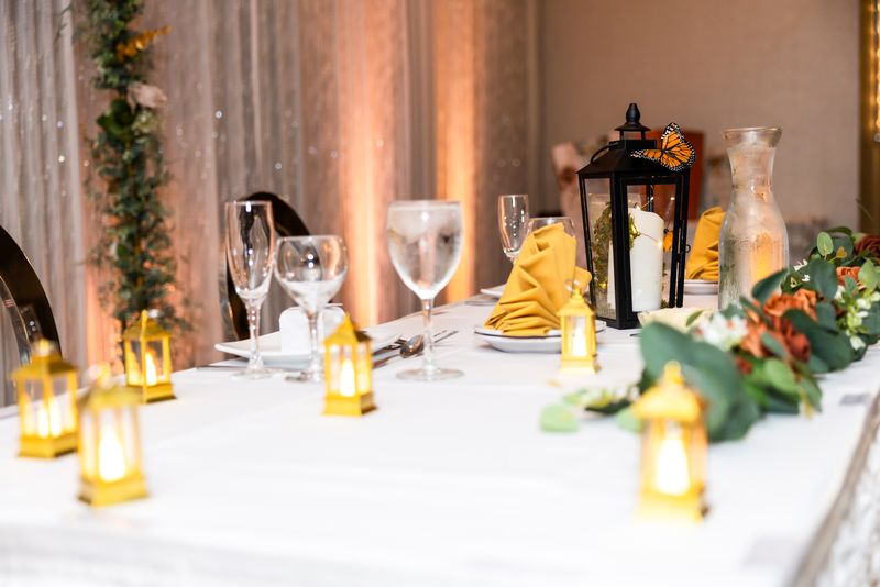 Head table detail with glowing gold lanterns and monarch butterfly