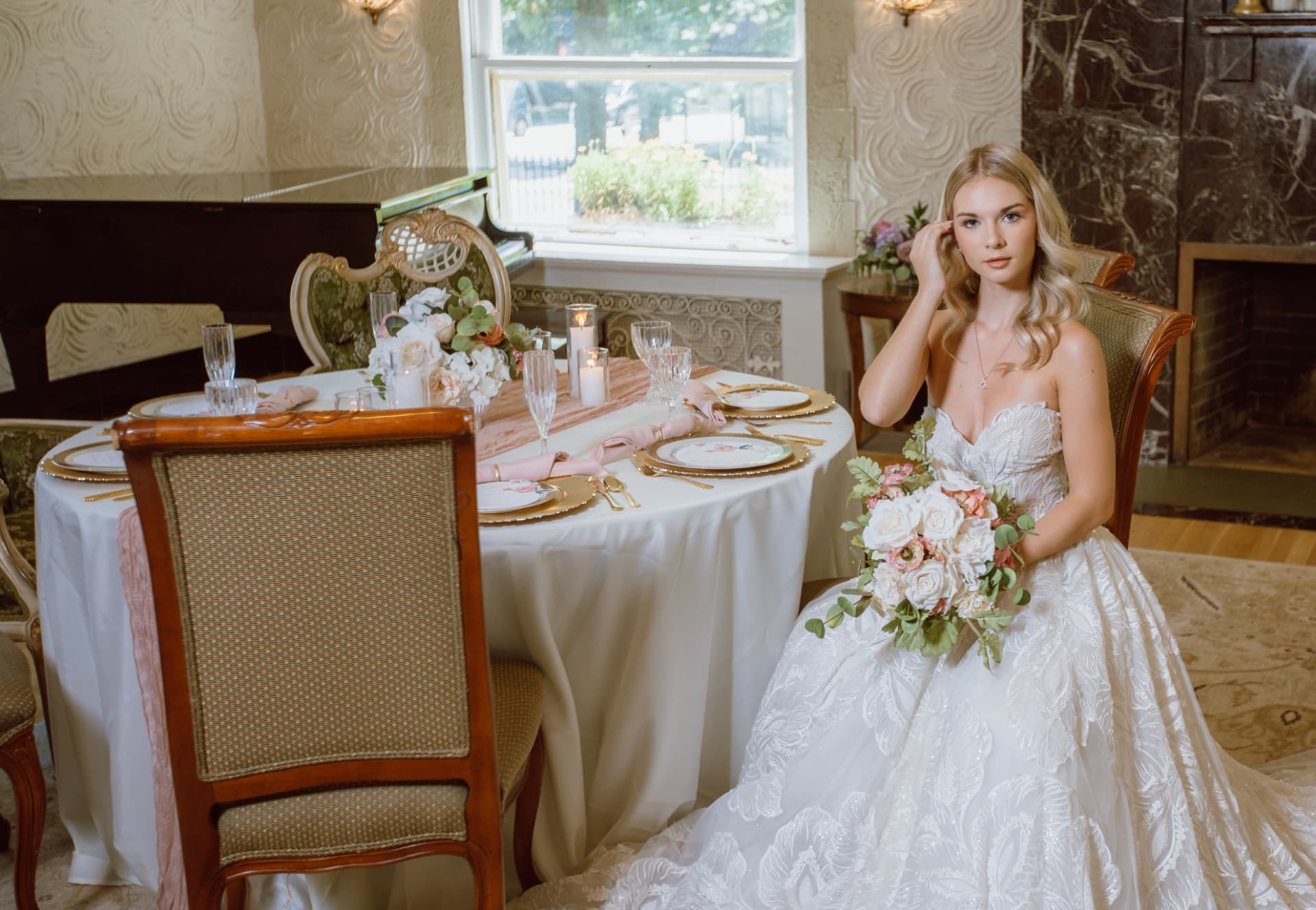 Bride seated at the blush tablescape with her bouquet