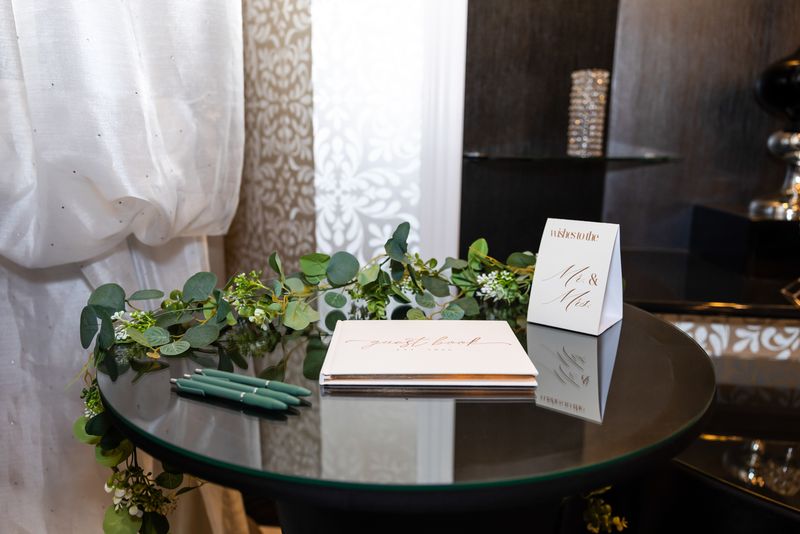 Guest book table with greenery garland and signing pens