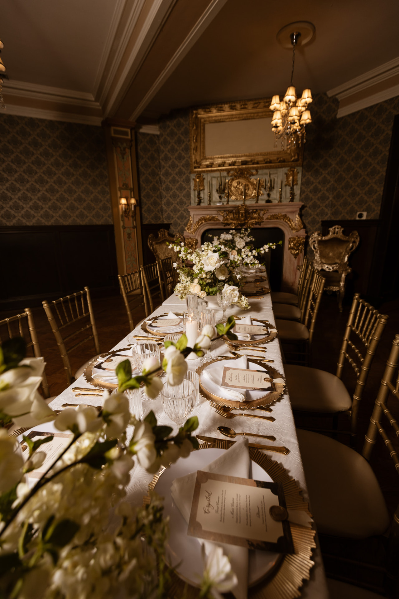 Candlelit head table beneath the gilded mantel at Stan Mansion