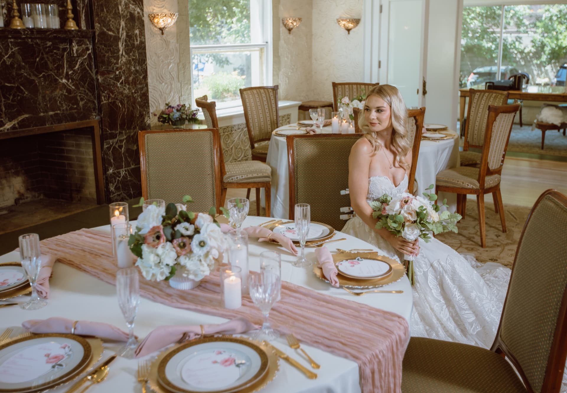 Bride at the reception table beside the marble fireplace
