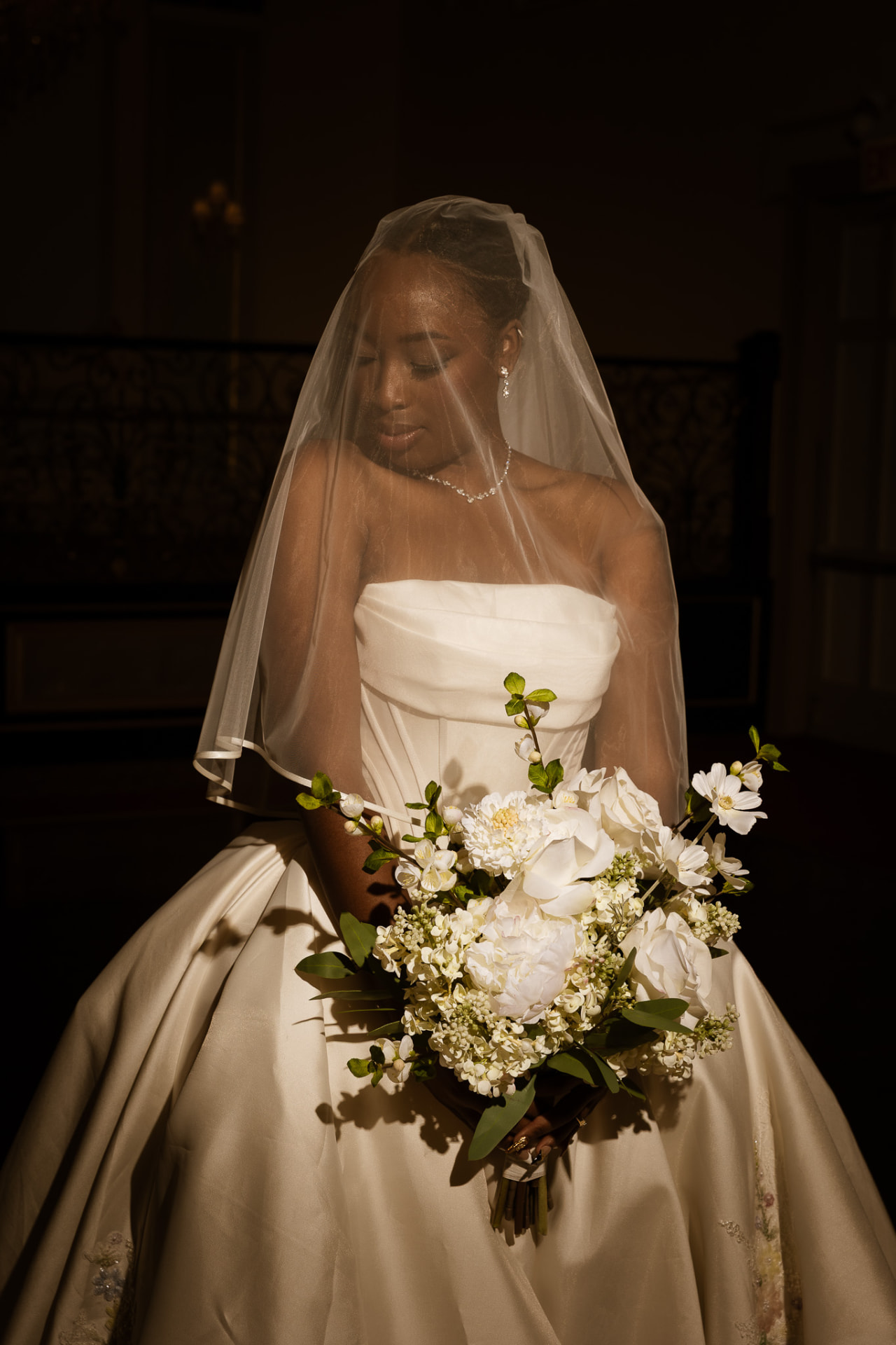 Bride veiled, holding a white garden bouquet