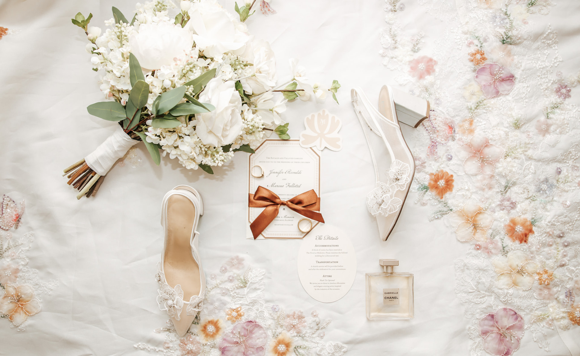 Bridal flatlay with white bouquet, invitation suite, and heels